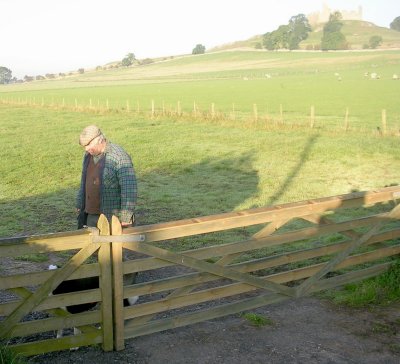 Scotman in filed with Sheep Dog, Hume Castle in background.